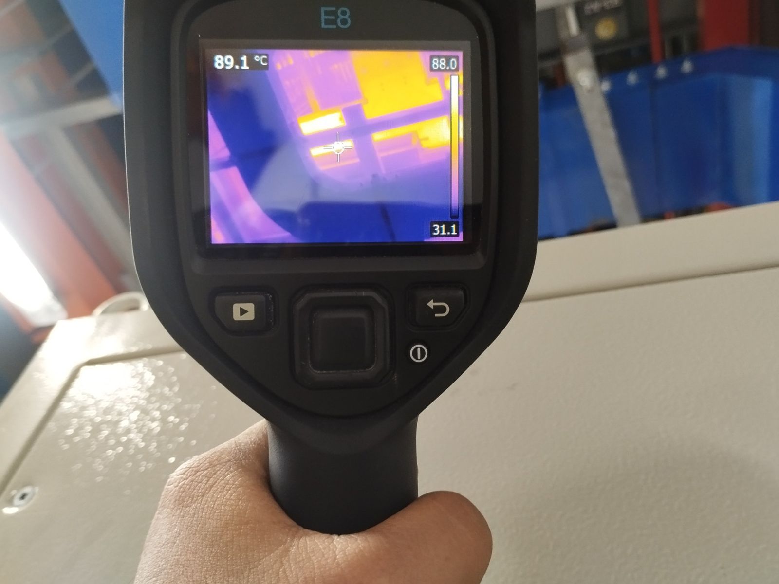 FLIR E8 aimed at an energised panel showing a spot reading of 89.1 °C
